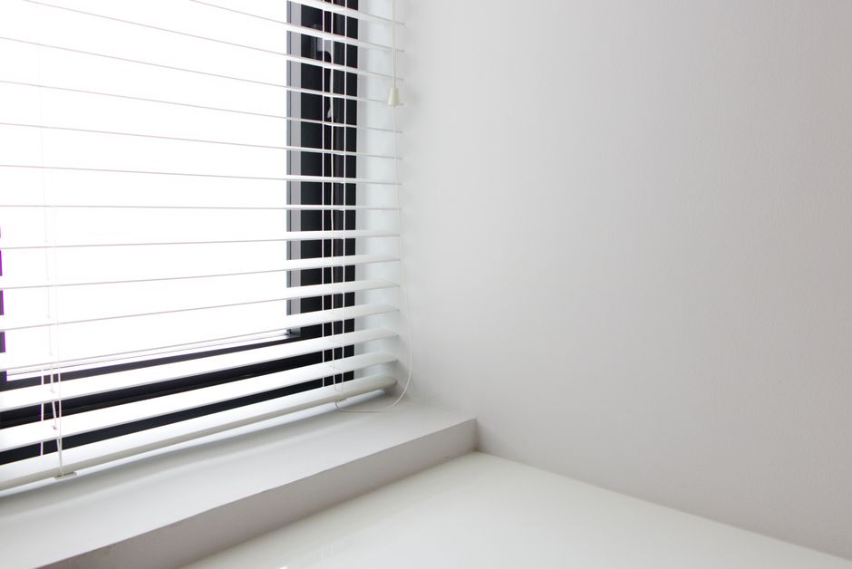 Professional installing window blinds in a home